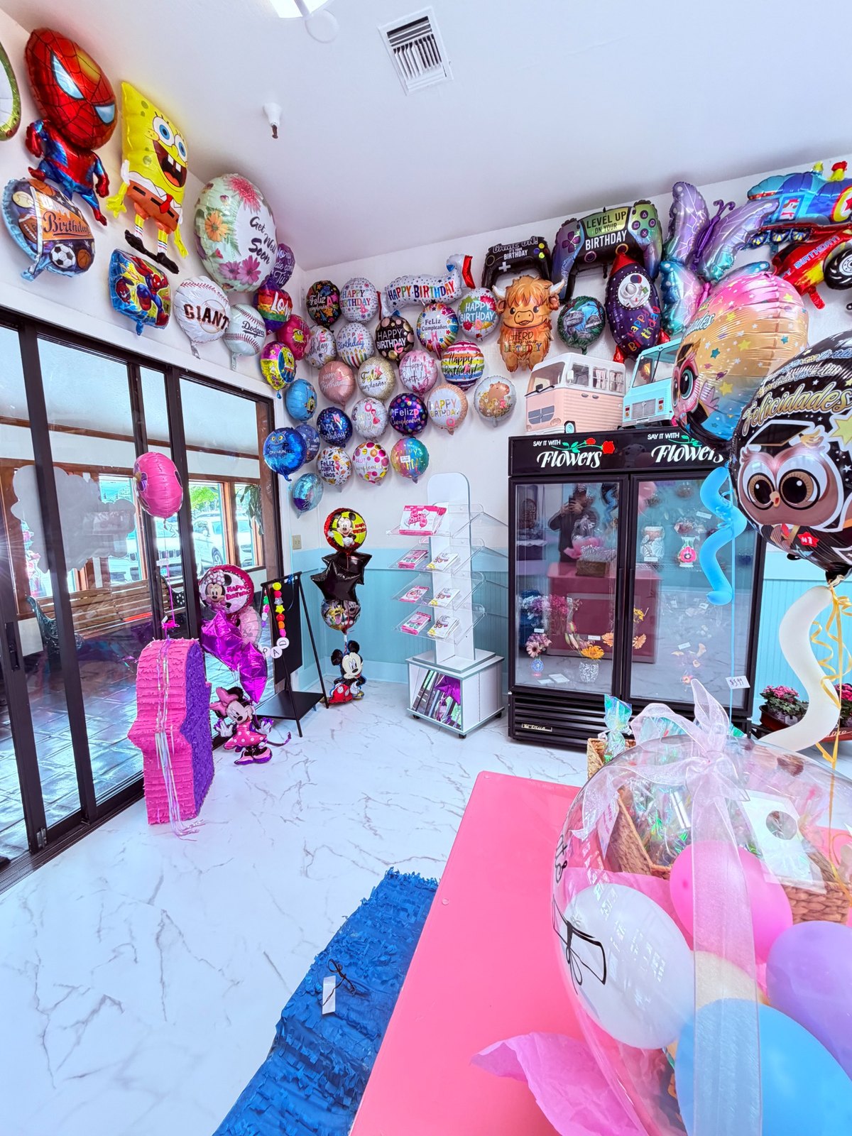 Store corner with balloons, piñatas, and flowers