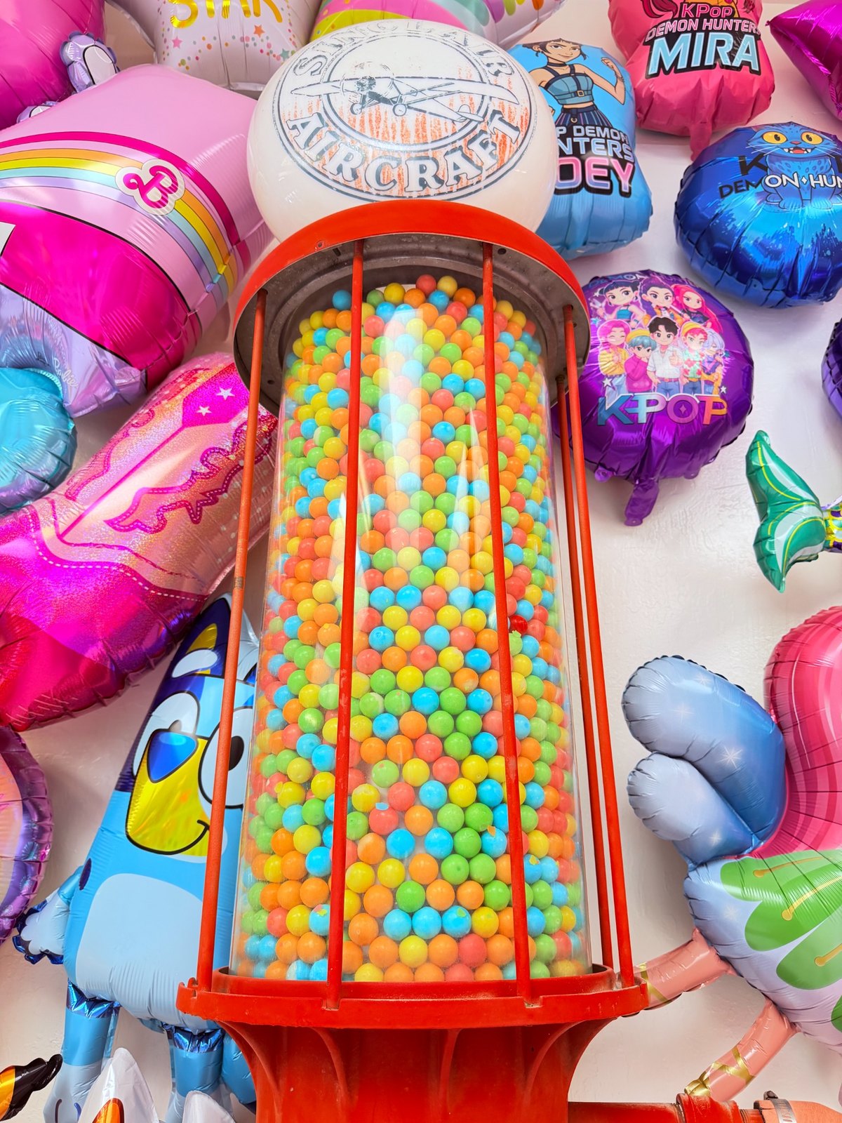 Gumball machine display surrounded by balloons
